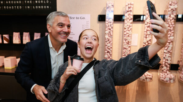 A George Clooney lookalike takes a selfish with a customer at the opening party for Grind's newest coffee store