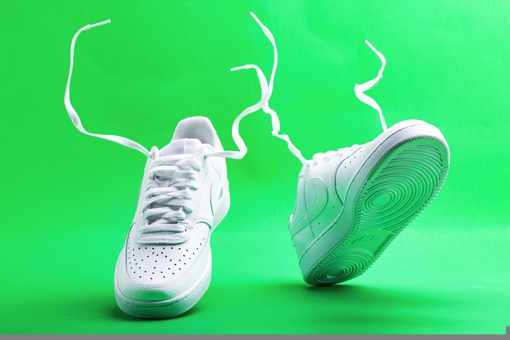 Flying white sneaker Nike on green background