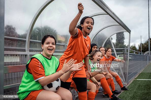 UNSPECIFIED, UNDATED: In this undated handout image, Sports Direct has created Equal View - a global image bank that aims to truly reflect the diverse reality of football and fan culture. The photo depicts female presenting player in red tops and green bibs cheering from the side of the pitch (Photo by Handout/Handout/Getty Images for Sports Direct)