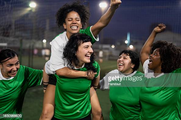 UNSPECIFIED, UNDATED: In this undated handout image, Sports Direct has created Equal View - a global image bank that aims to truly reflect the diverse reality of football and fan culture. The picture depicts female presenting footballer's in green and white shirts celebrating, with one player on another's shoulders. (Photo by Handout/Handout/Getty Images for Sports Direct)