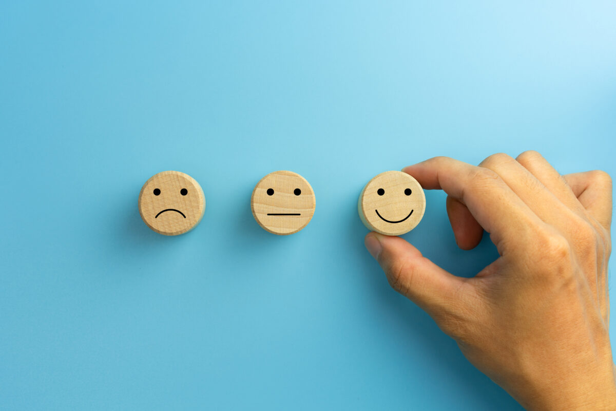 Enjoyable creativity in advertising remains a major driver in the public's trust, yet factors like a person's worldview can still affect their experience. here depicting a sad face, a neutral face and a happy face on a light blue background.