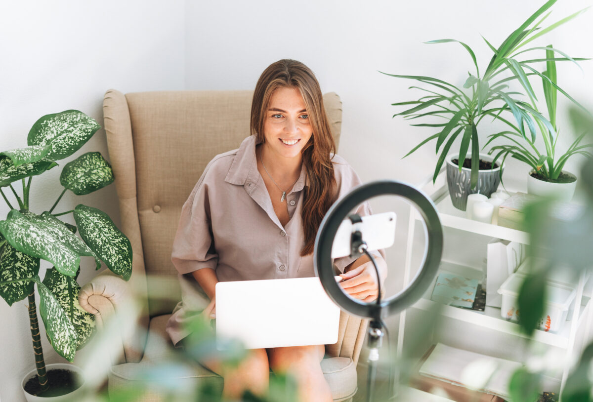 Content creators are holding back on promoting sustainability amid greenwashing fears and a range of other barriers, a new Unilever study reveals, here depicting an influencer recording herself and surrounded by various house plants.