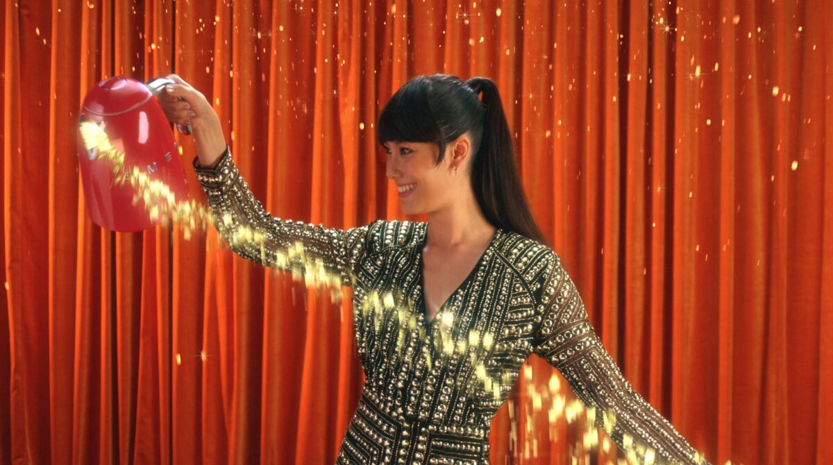 Digital department store Freemans has dropped its Christmas campaign early this year, in an aim to grow its existing customer base and attract new shoppers, here depicting a still from the TV campaign - a lady in a dress with CGI sparkles and a red curtain background
