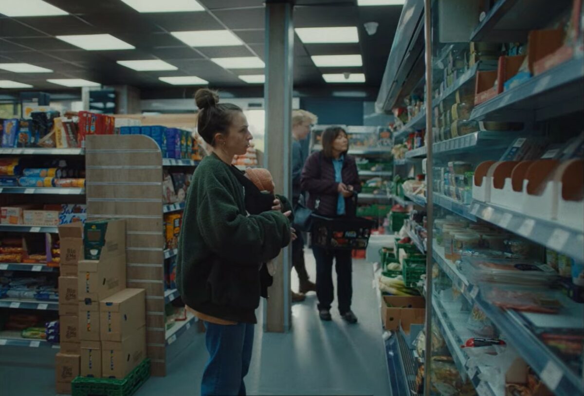 NSPCC has unveiled a new campaign to raise awareness of the postnatal mental issues that can arise after the life-changing event of giving birth, the image depicts a mother with a newbrn strapped to her chest in a supermarket - looking blankly at the products in front of her. Slightly unfocused is a fellow shopper. 