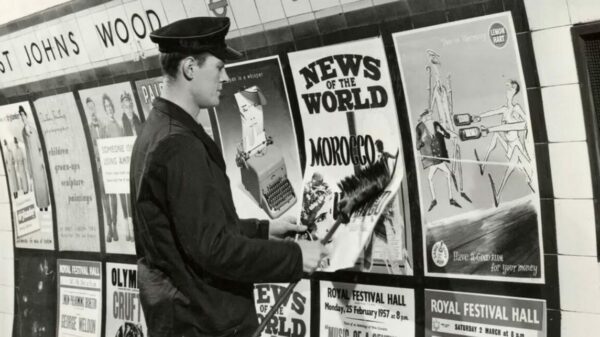 Transport for London's (TfL) poster exhibition look back at the network's early history of posters - from political advertising to brand commissions, here depicting a vintage photo of a TfL worker hanging poster's within the network
