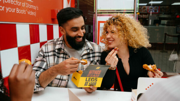 Gymbox Morleys collab, people eating out of Gymbox chicken boxes. Gymbox will partner with the high street classic chicken shop Morley's as it brings its latest OOH campaign to life, in a bid to show how the gym embraces Londoner's through every aspect of their lifestyle.