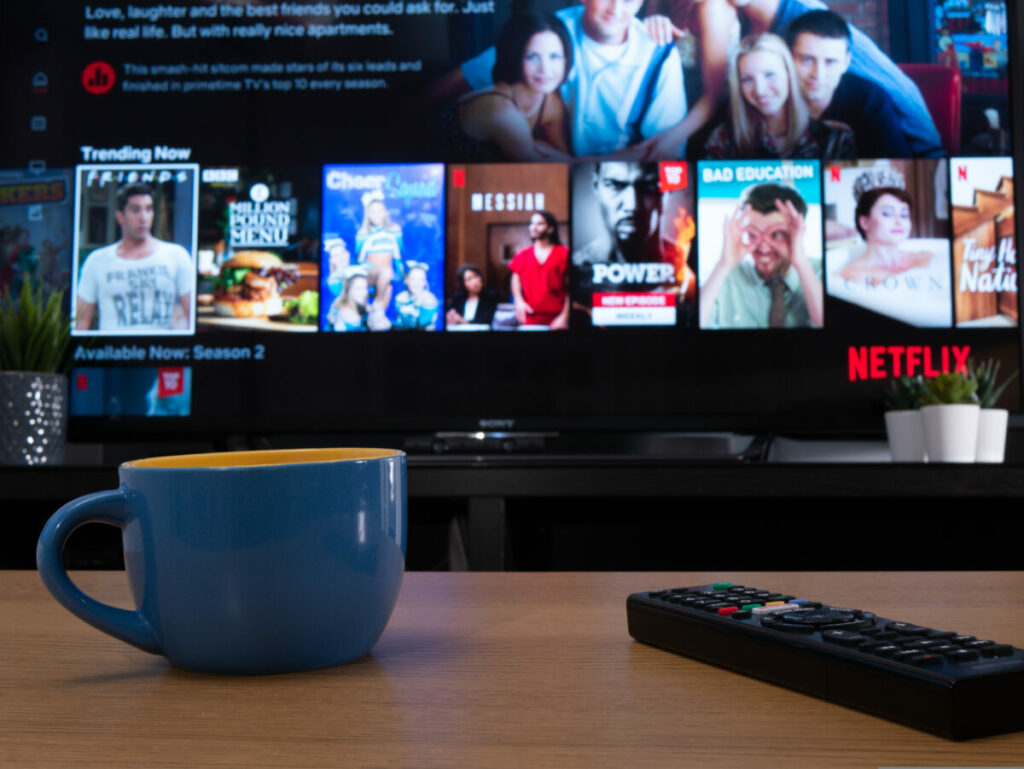 Netflix on a living room tv screen. Netflix's ad-supported tier has surpassed 23 million global active users per month, the figure comes just one year after the streamer launched it.