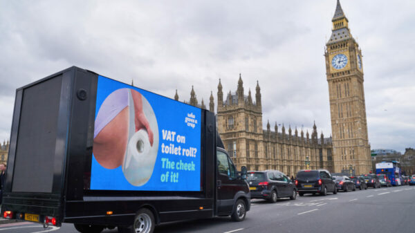 Image of Who Gives A Crap van in front of Parliament reading "VAT on toilet roll? The cheek of it?2 accompanied by an image of someone holding toilet roll in their knickers. Who Gives A Crap urges gov to "scrap the roll tax" in fresh stunt