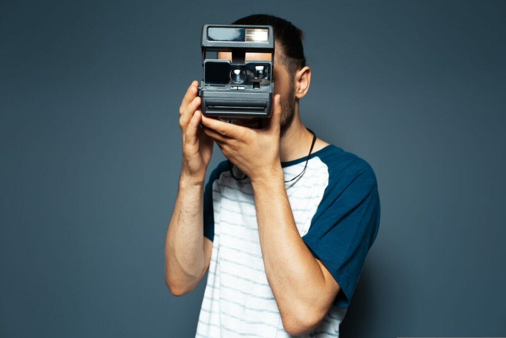 Man holding Polaroid. Polaroid has appointed Brainlabs as its agency of record to manage its media planning and buying services.