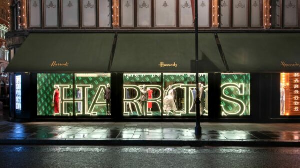Harrods store front with Harrods word lit up. Harrods has launched a campaign to celebrate its 175th anniversary, including a presentation on its façade, a light show and new window displays.