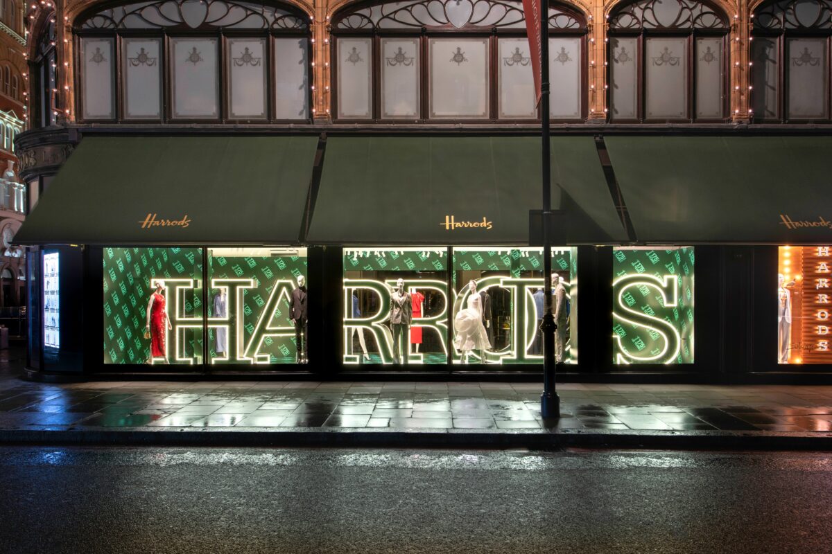 Harrods store front with Harrods word lit up. Harrods has launched a campaign to celebrate its 175th anniversary, including a presentation on its façade, a light show and new window displays.