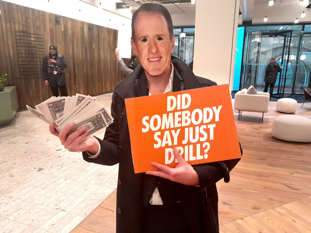 Activist holding "Did somebody say just drill" sign in McCann Worldgroup London HQ. A team of Extinction Rebellion activists infiltrated the London HQ of McCann Worldgroup, in protest about the company's link with Saudi Aramco.