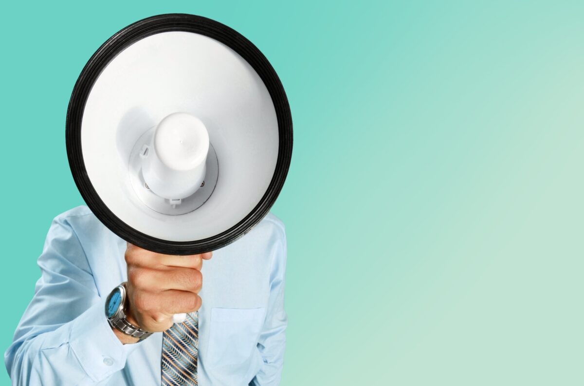 Businessman with a megaphone. The megaphone covers his face. New findings from a study looking into the impact of OOH on attention, reveal that participants attention increased with each exposure to a specific ad.