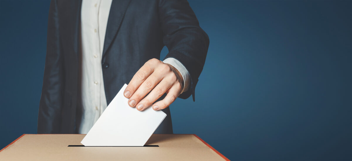 A man in a suit puts ballot in polling box. The UK trade body Advertising Association has issued the new set of guidance to help young voters better understand political advertising.