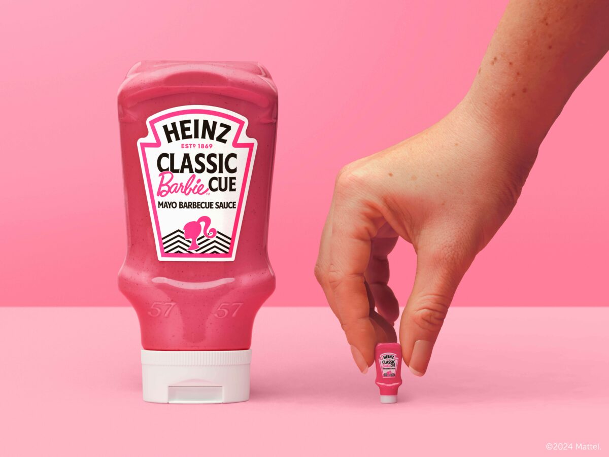 The pink coloured Barbie cue sauce in the traditional Heinz bottle is shown with a Barbie logo on it and a modern image of a woman in a pony tail and then a modern style pattern next to it. To the side of the bottle is a hand with a mini version of the bottle. The background is also Barbie pink.