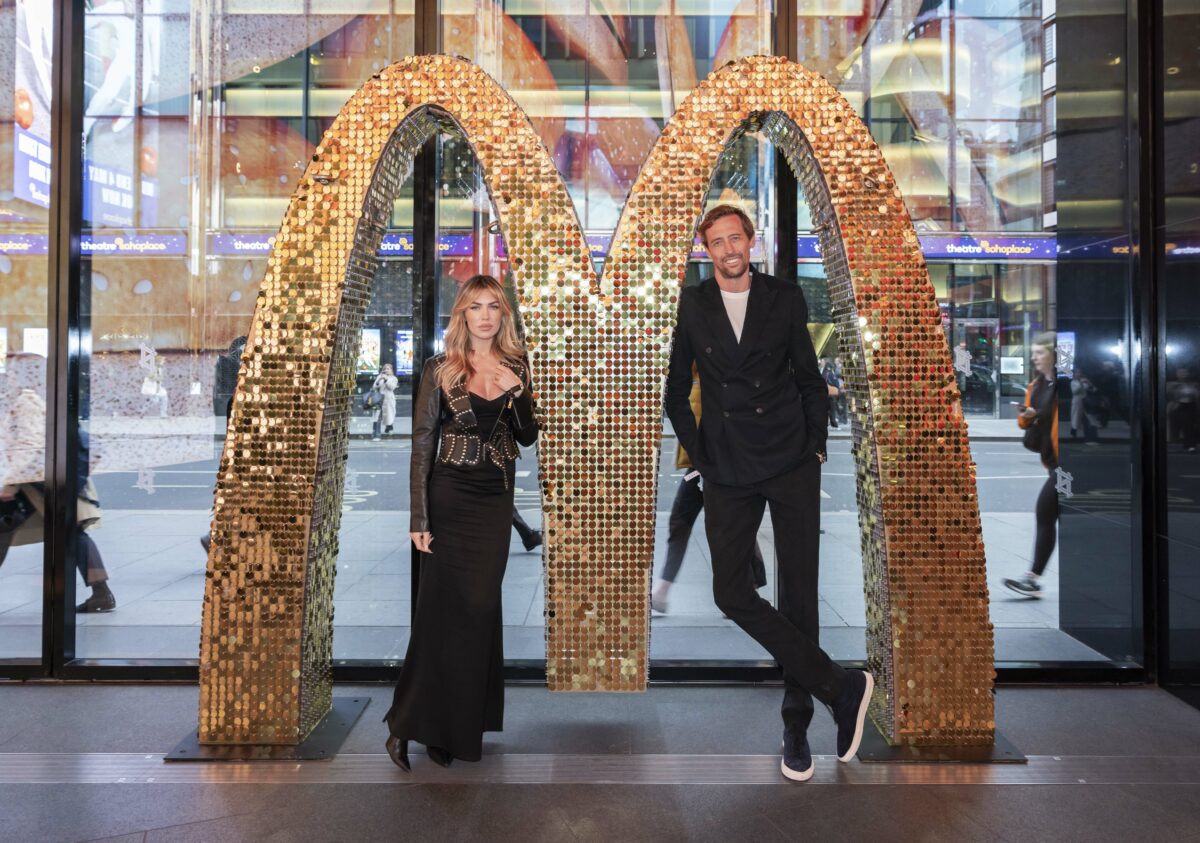 Image shows Peter Crouch and Abbey Clancy in front of a glitzy giant golden M as part of the 3D experience launch at the Outernet in London. McDonald's has  created a new multi-sensory 3D experience live today (April 18) building on its "A little more Mmm" campaign, with the multi-channel campaign set to showcase improvements made to its hero beef products.