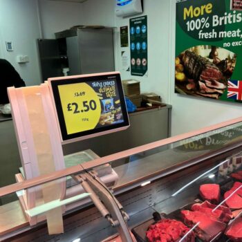 A morrisons meat counter with steaks. A bright digital screen advertisers chips with a reduced offer, £3.69 down to £2.50. It reads "Triple cooked. Ultimate taste."