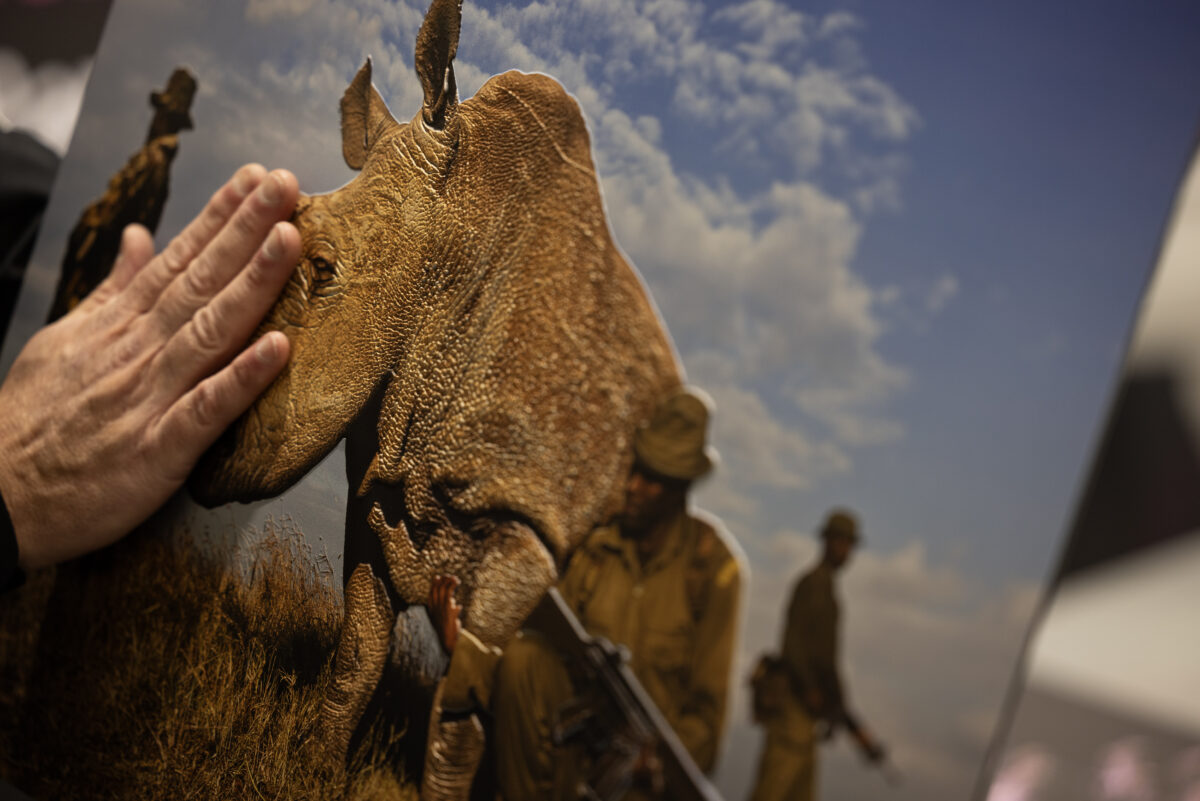 A hand traces a 3D tactile printed image of the last male rhino in Sudan surrounded by heavily armed conservation rangers who are dedicated to protecting him. The image was taken by South African photojournalist Brent Stirton on a Canon EOS 1Ds Mark II.