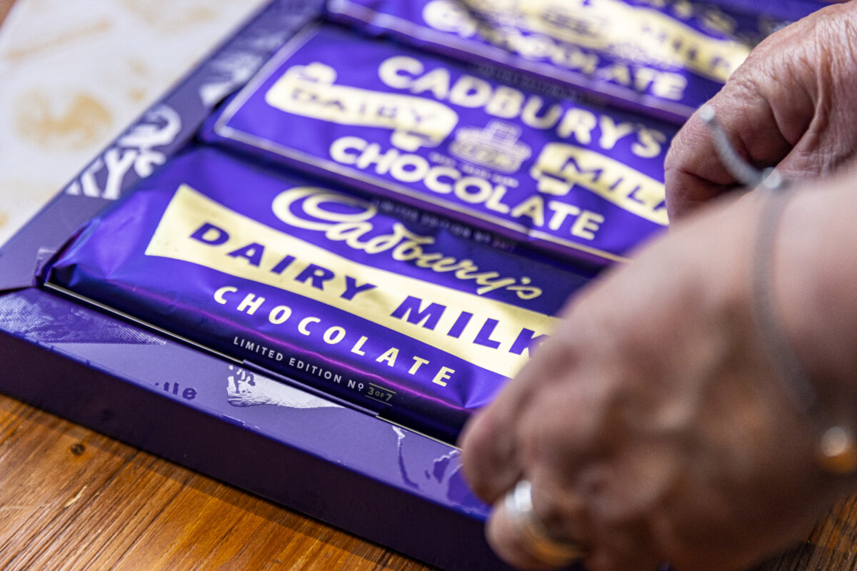A person with a silver ring places down a box of Cadbiry bars with vintage packaging, rejigging the memories of years gone by. Cadbury and Alzheimer's UK have distributed 4,000 memory bar boxes to people living with dementia and their loved ones to coincide with Dementia Action Week (13 May to 19 May).
