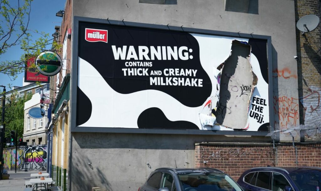 Billboard features a Frijj Milkshake shaped hole which has been ripped through as if the milkshake's been snatched, a cow patterned background and the words Warning: contains thick and creamy milkshake. Frijj is bringing its iconic "Feel the Urjj" tagline to life with a cow-themed set of billboards, in order to big up the enticing power of its milkshake.