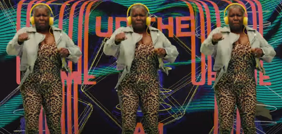 Hype Gran wears a leopard print outfit and a jean jacket with yellow headphones, she concentrates as she jumps up and down feeling the beat. Watch: Jam Shed wine signs Hype Gran to "pump up" passion