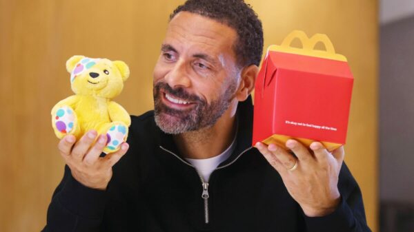 Rio Ferdinand holds up a Pudsey Children In Need toy and one of the new Happy meal boxes which has the happy smile removed and has text reading "It's ok not to feel happy all the time". McDonald's has removed the happy smile from its happy meal boxes for the first time, effort to encourage family conversations about mental health fronted by Manchester United legend Rio Ferdinand.