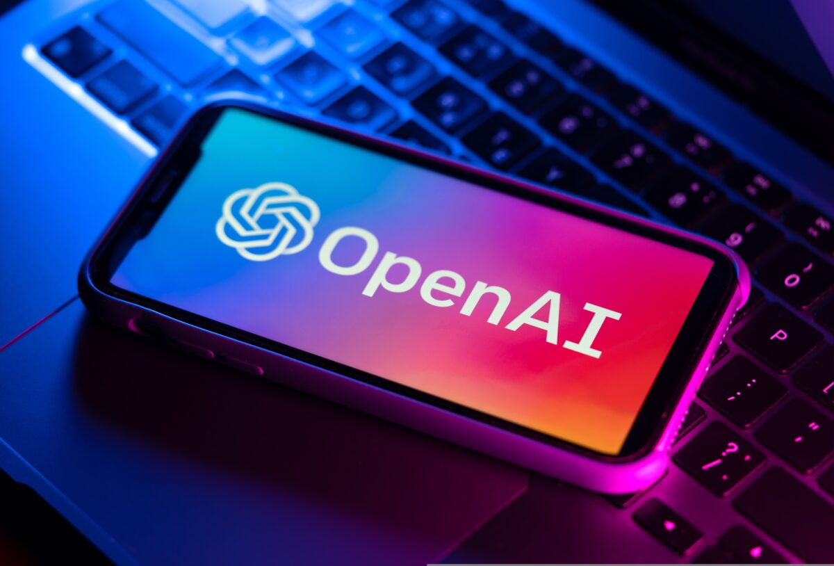 Open AI branding on phone and laptop. Open AI has announced a new deal with News Corp under which it will be able to display news content from the mastheads.