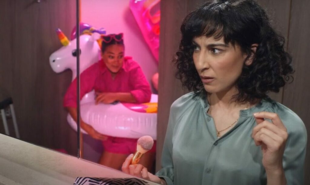 Woman shocked as a lady with a rubber ring dressed in pink attire and holiday ready exits the toilet cubicle. LastMinute.com has shared a new set of assets that play on urgency by showing the array of places modern technology allows people to book holidays.