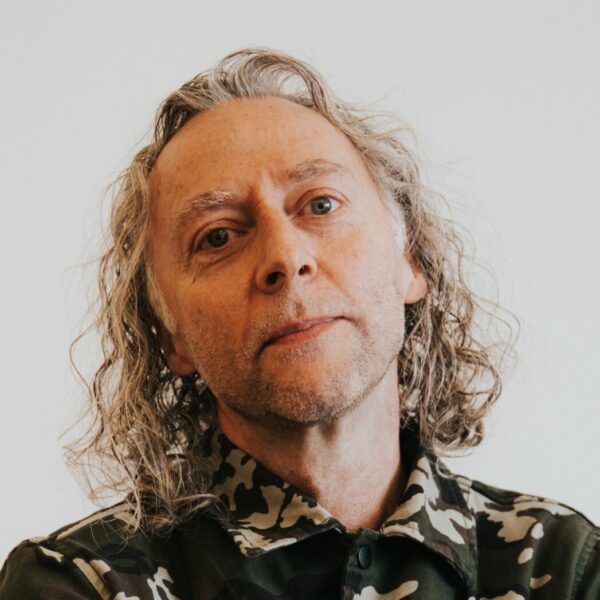 John Mescall wearing a camouflague shirt and tilting his head. Former president of McCann's global community John Mescall, is joining by The Network as creative chair.