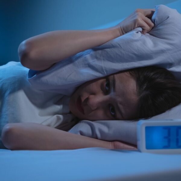 Woman kept awake by alarm. Alarm reads 3 am. She squashes her head in the pillow. CIM study reveals marketers are tossing and turning due to a range of issues, with over half fearing burnout due to the industry's culture (56%), according to new research from the Chartered Institute of Marketers (CIM).