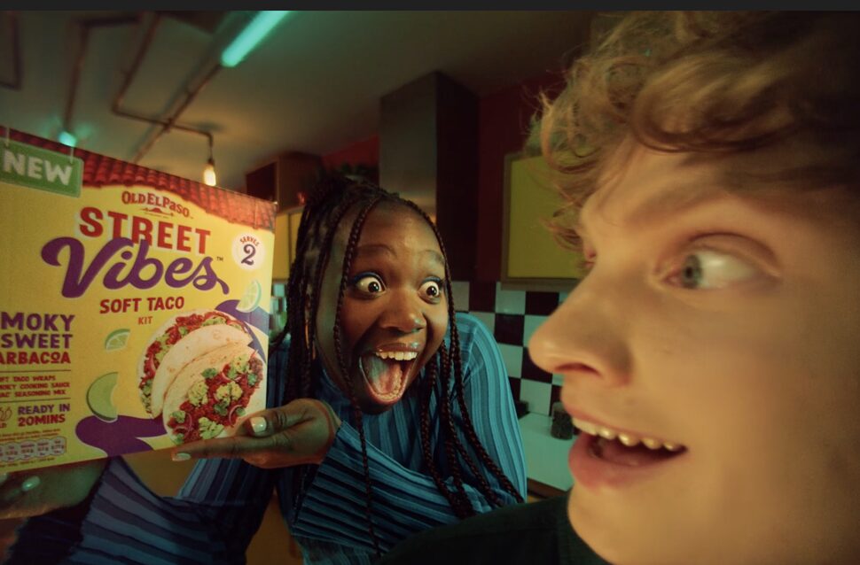 An excited young woman holds up a pack of Old El Paso Street Vibes. Old El Paso has made its first foray into laptops, phones and smart TVs across the country by launching a new 'Turn It Up' campaign to ramp up Gen Z interest in its new Street Vibes range.