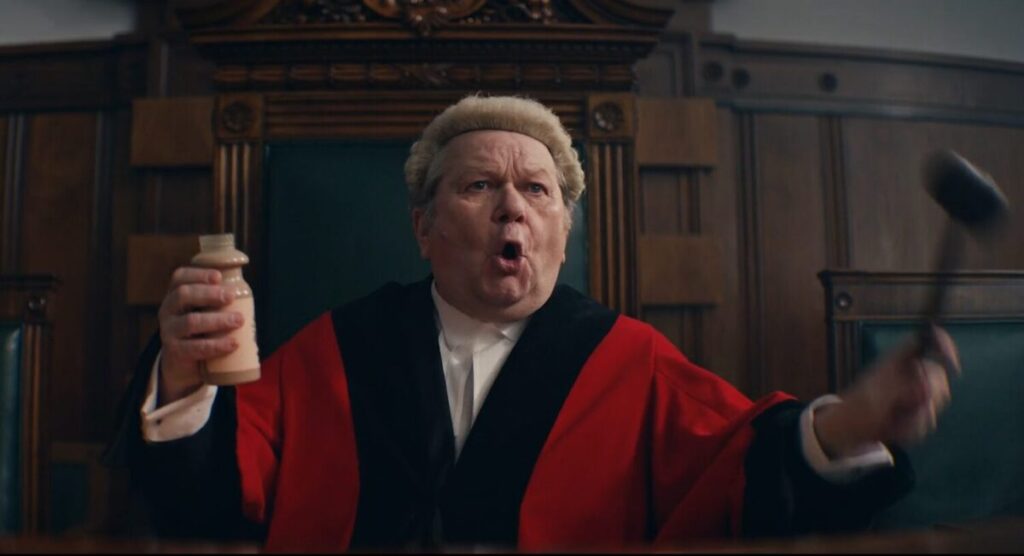 Image from Shaken Udder's recent advert - a judge exclaims dramatically whilst holding up a bottle of Shaken Udder and his hammer. A new analysis of 500 adverts carried out by effectiveness platform  System1 and ITV reveals an overall increase in performance, with more new adverts achieving at least "modest" ratings.