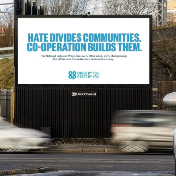 A Co-op billboard reads Hate divides communities. Co-operation builds them. Co-op is showcasing its work with community causes in a bold new out-of-home campaign created to mark National Inclusion Week. 