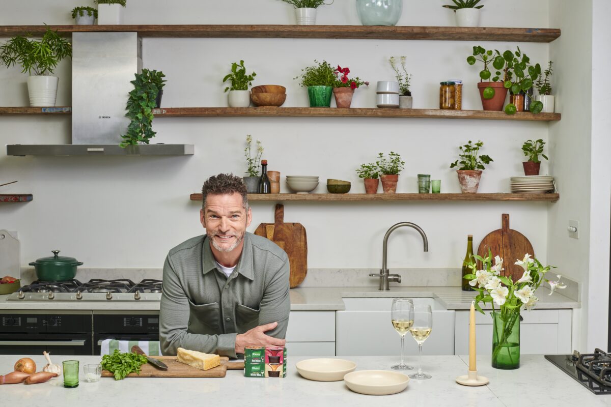 Fred Sirieix leans on the kitchen counter with his prepped veg, a couple of glass of wine and Knorr red wine stock pots. Stock brand Knorr stars celebrity maître'd Fred Sirieix in its newest campaign which highlights how the brand's stock pot range can save midweek meals.