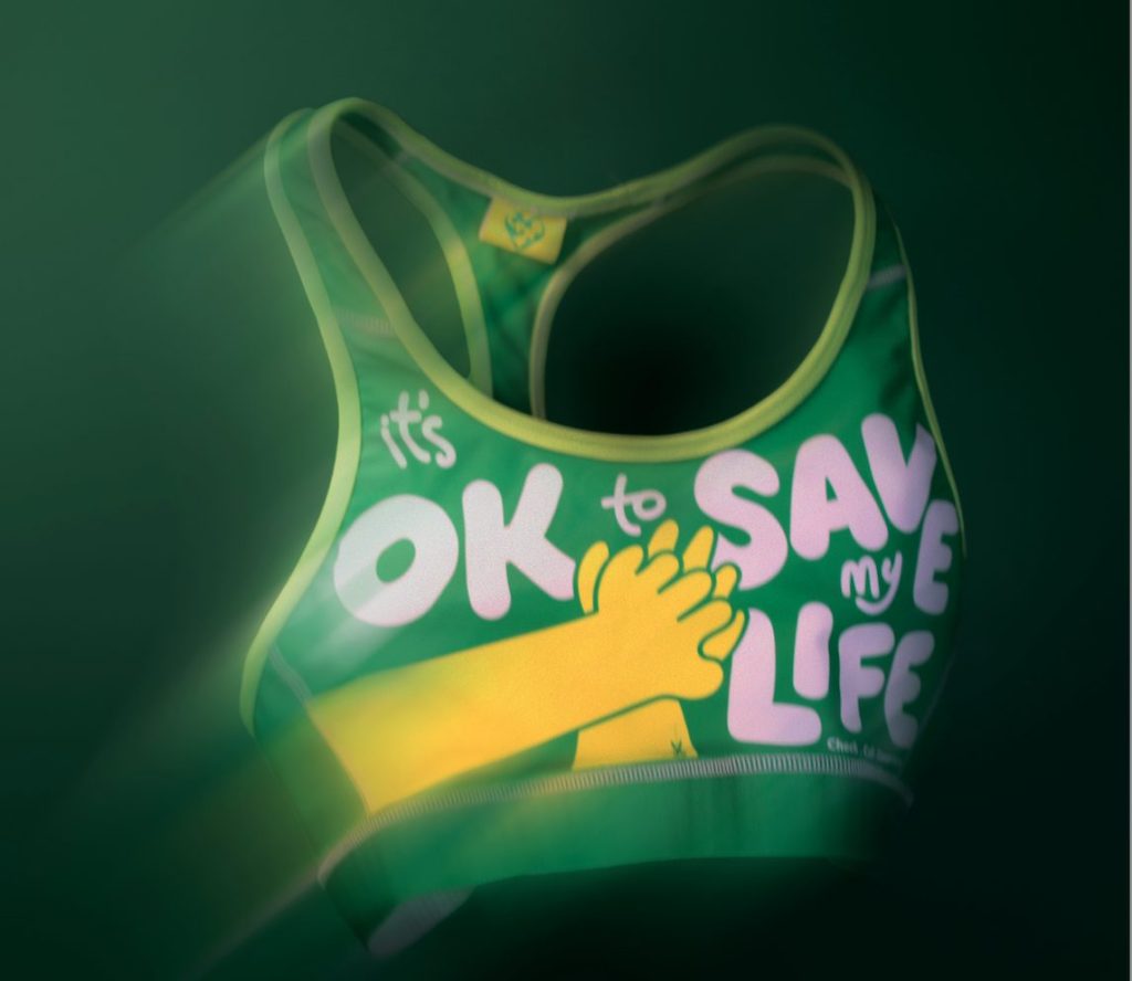 Green CPR bra with text "It's ok to save my life" on the front. St John's Ambulance joins forces with Revolt and Fight or Flight agencies to tackle the fact that a third of Brits are afraid to give CPR to women.