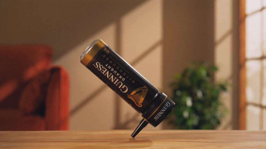 A dancing Guiness nitrosurge device balances on a table in style. Guinness gives a nod to its iconic 1994 'Dancing Man' ad in a film showing a dancing can to illustrate how the nitrosurge device creates the perfect at-home pour.