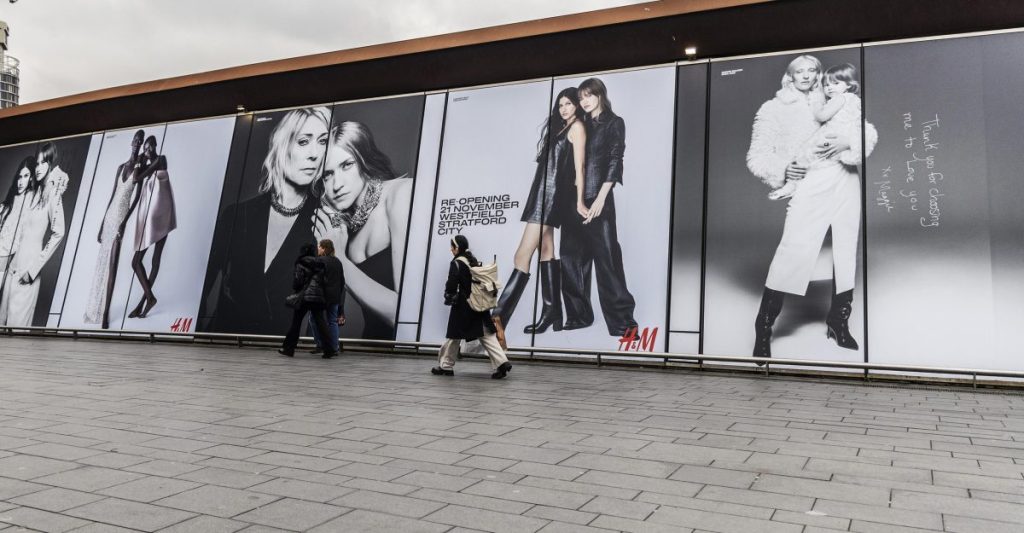 Fashion brand H&M has transformed Westfield Stratford's bustling pedestrian bridge into a festive branded walkway. 